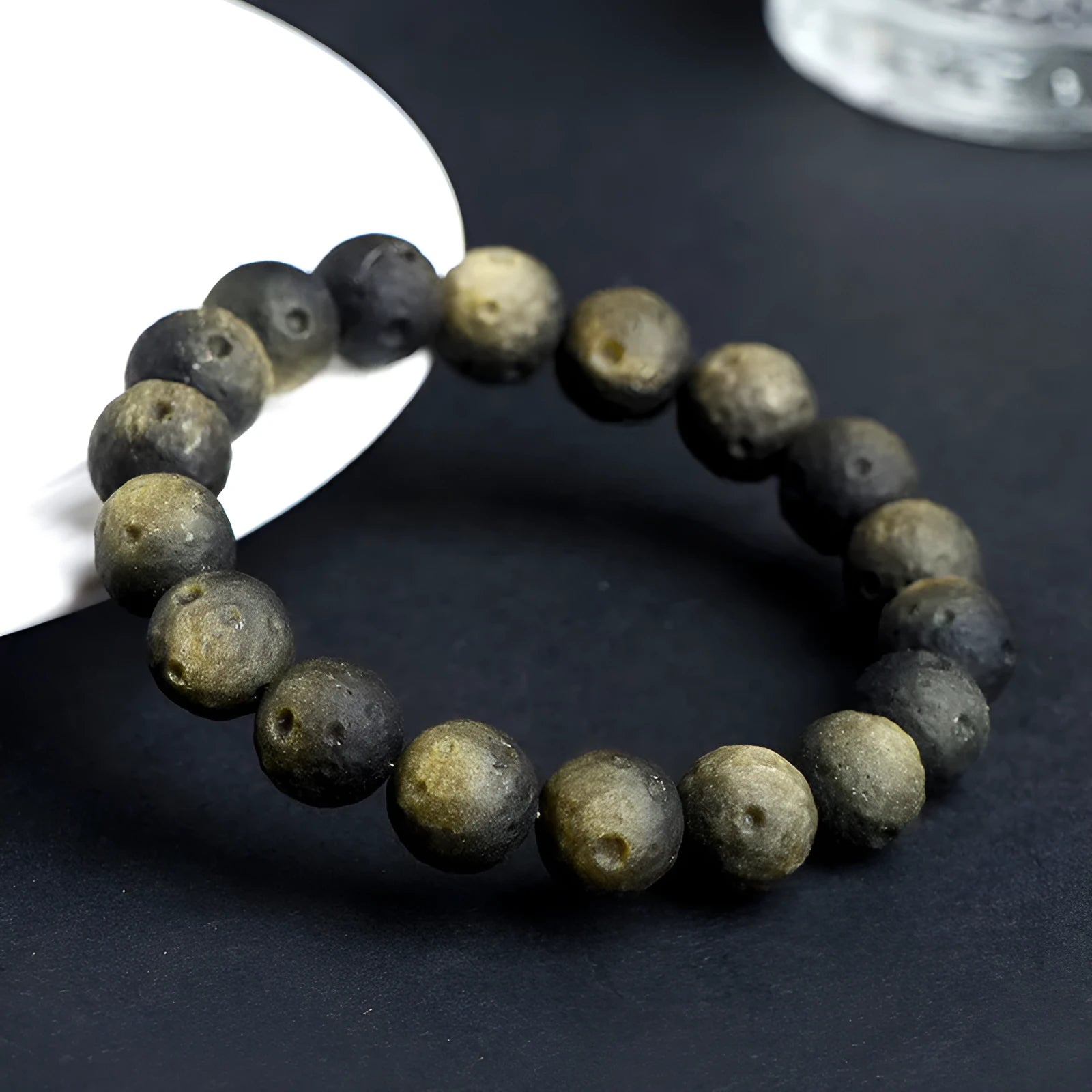 Natural obsidian crater ball bracelet in silver or gold finish, showing textured bead detail.