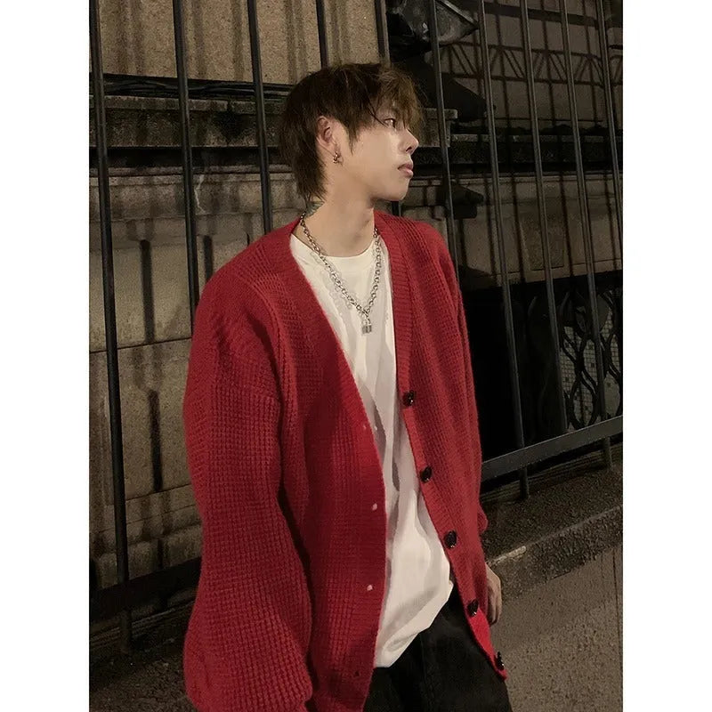 Men's solid colour V-neck knitted cardigan sweater in a loose fit on a hanger.