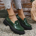 Women's black slip-on loafers with a chunky platform heel and rubber sole, shown from the side.