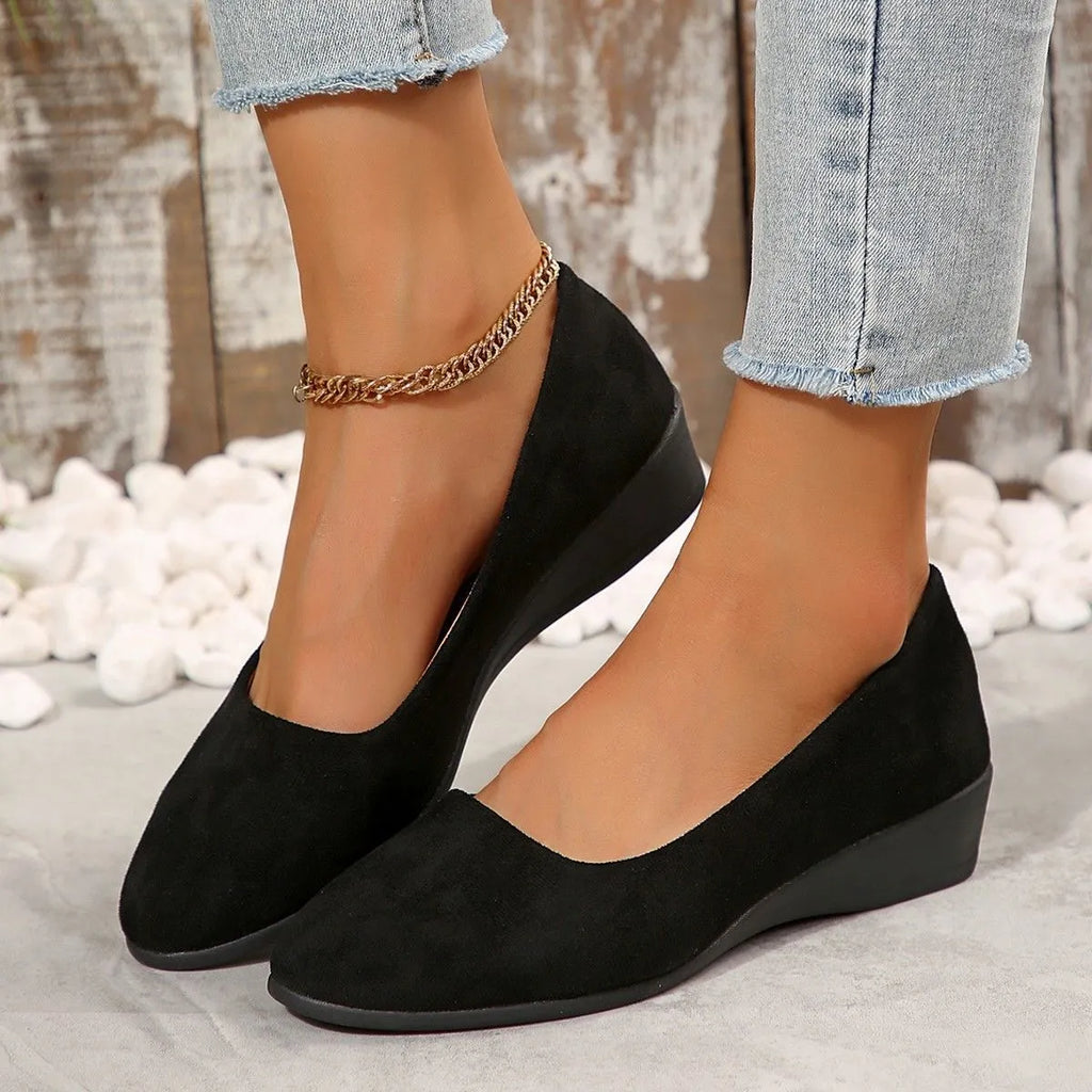 Women's light brown suede wedge pumps with a round toe and shallow mouth design on a rubber sole.