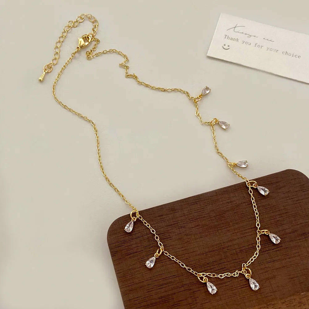 Zircon jewellery set with geometric necklace, matching earrings, and anklet.