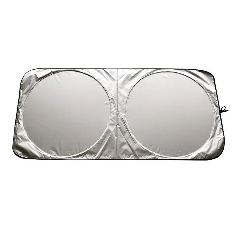 Large silver reflective car sunshade folded next to its cloth storage bag