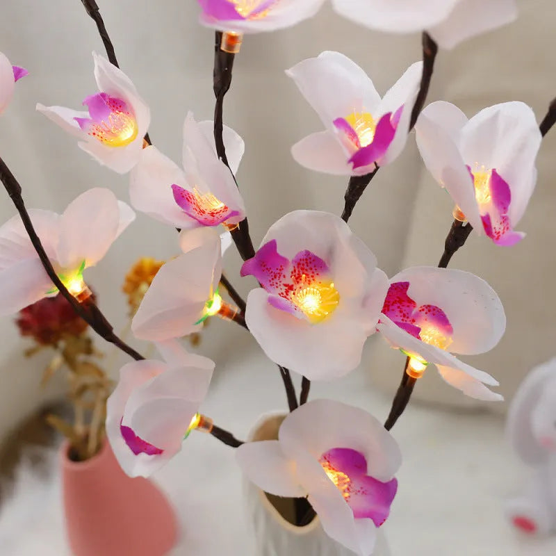 Pink phalaenopsis orchid branch decorative light with 20 LEDs, standing 65cm tall on a table.