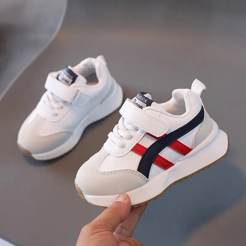 Children's white casual sneaker with Velcro strap and rubber sole, shown in sizes 21-30.