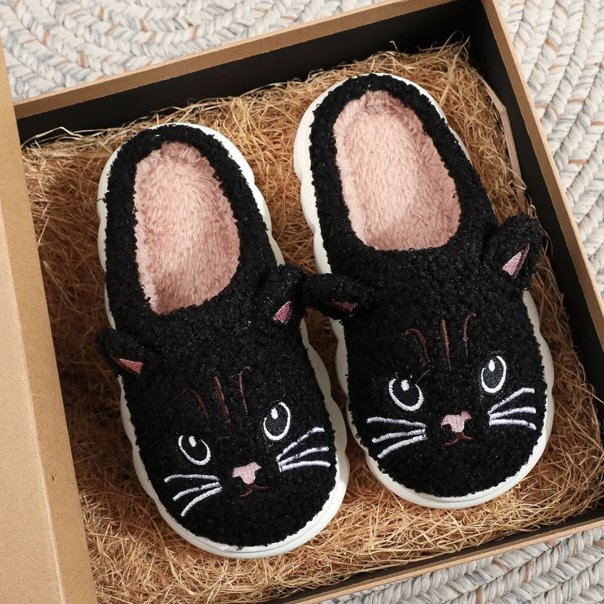 Pair of pink winter cartoon cat fluffy slippers on floor, non-slip EVA sole
