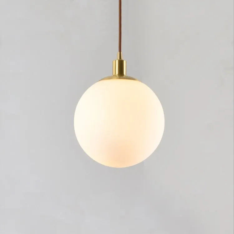 Nordic glass round spherical chandelier in milk white with copper fittings on a light background