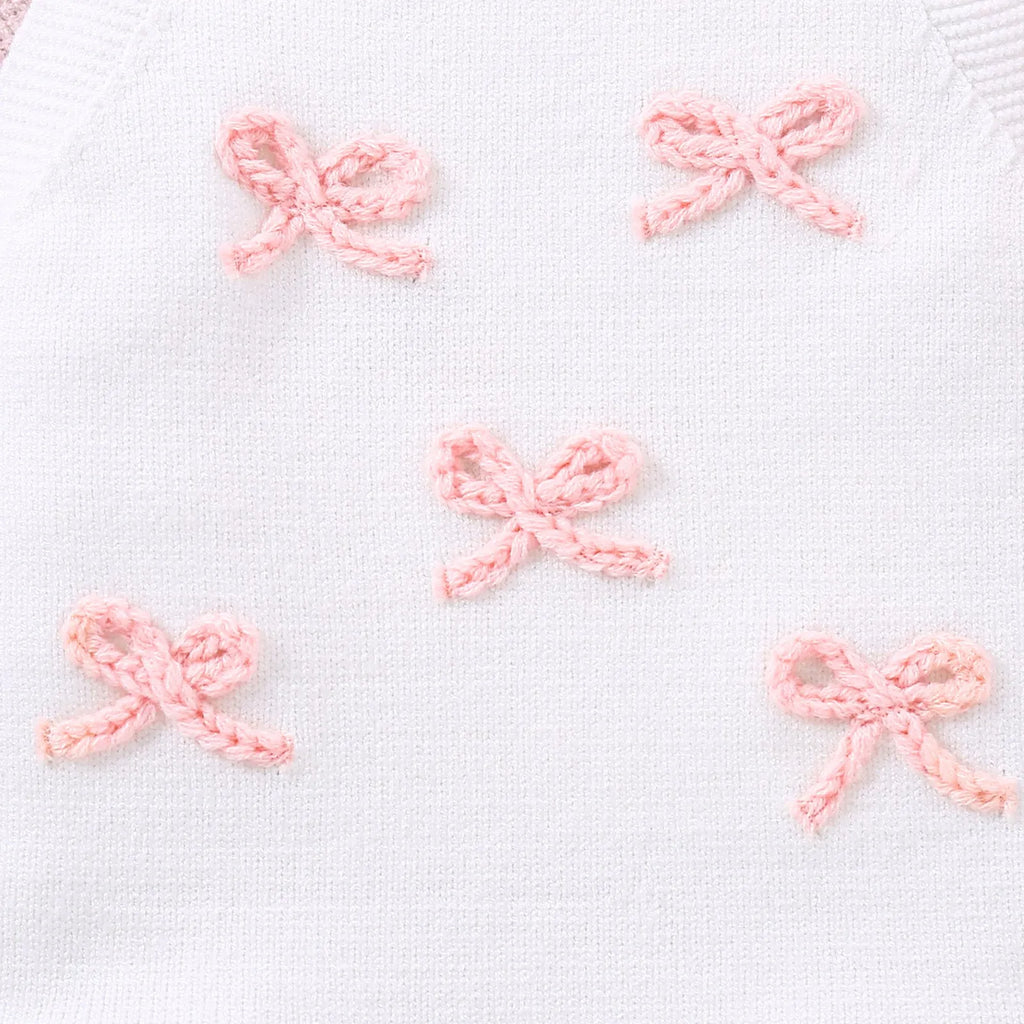 Baby girl sling romper in white with bow embroidery on wool blend fabric.