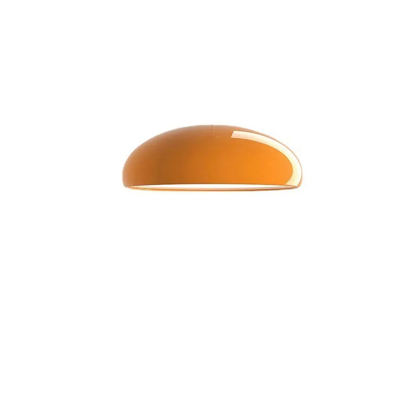 Danish iron pendant lamp in orange with adjustable cable hanging over a restaurant table.