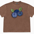 Loose fit blueberry fruit patchwork print short sleeve T-shirt on a hanger.