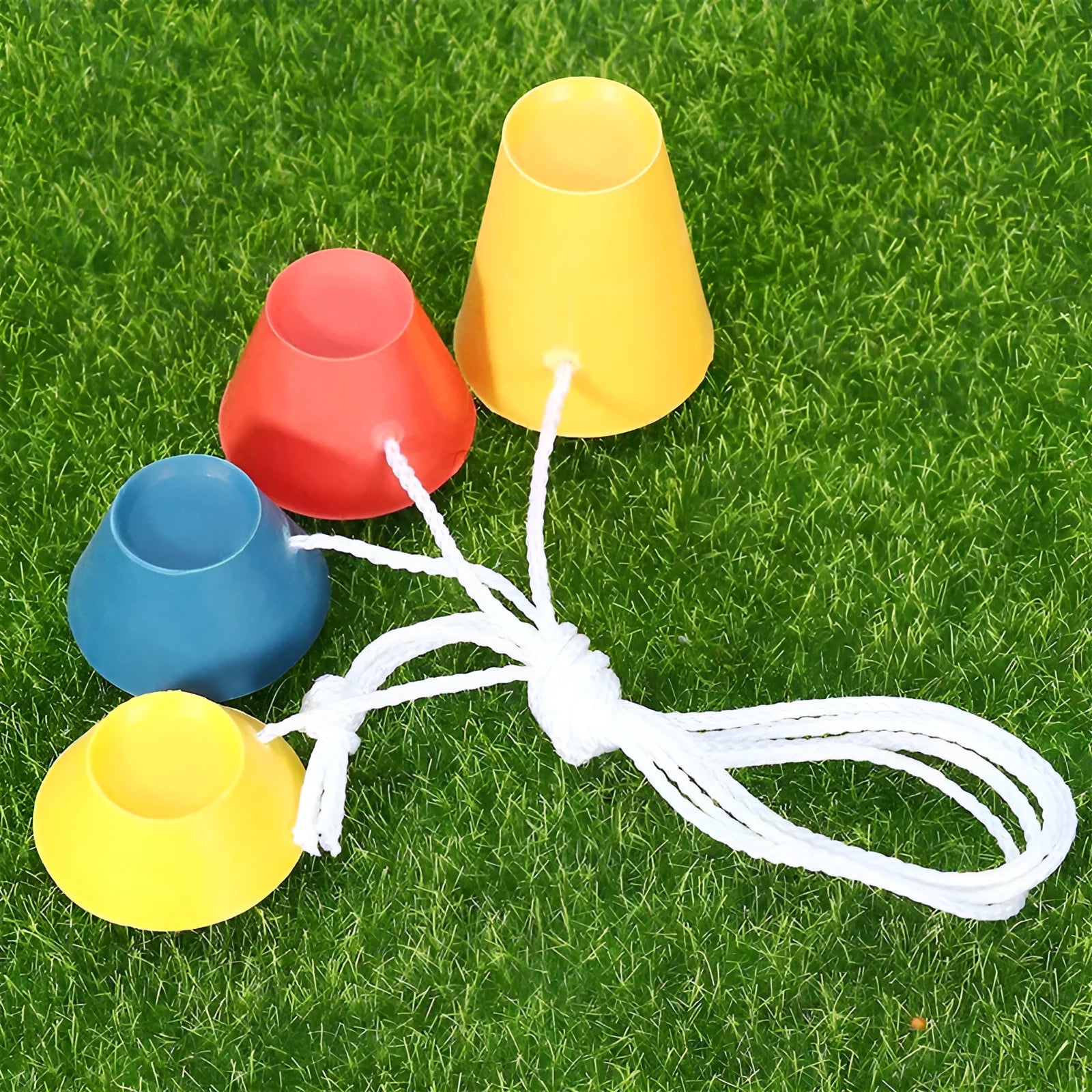 Set of four rubber golf tee ball holders in blue, yellow, and red with four feet each, 2cm height