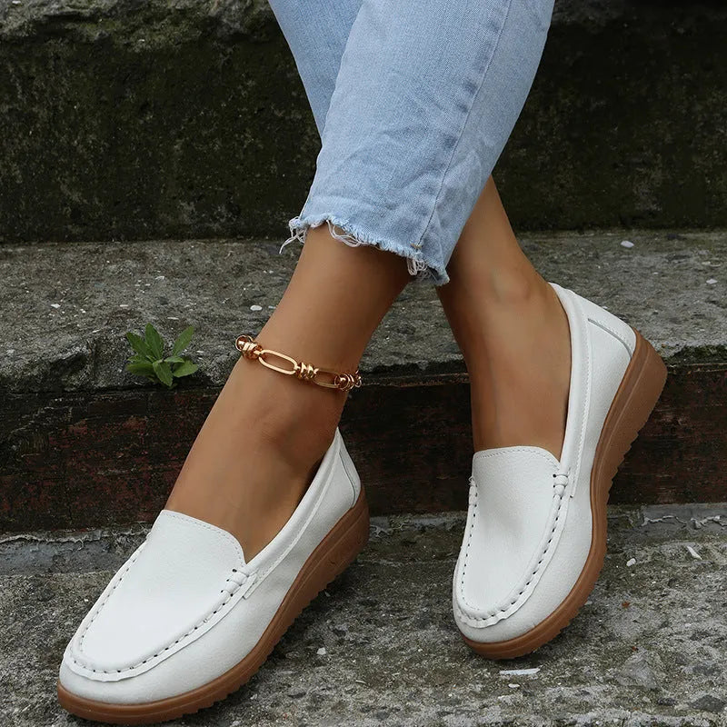 Women's PU leather flat shoes with round toe and rubber sole in black, white, red, blue, and orange colours.