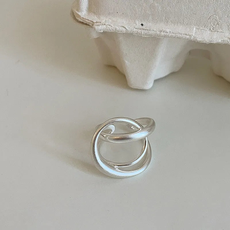 Geometric open ring with 3D interlaced pattern in matte metal finish