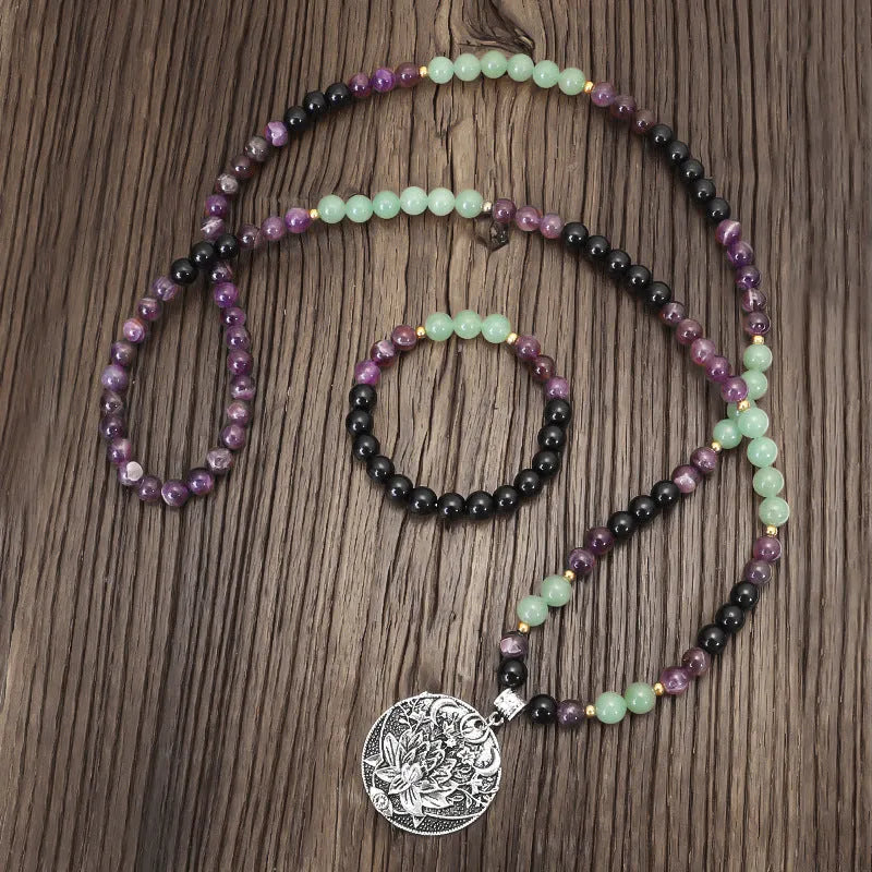 Yoga lotus pendant necklace and bracelet set with stone beads on a white background