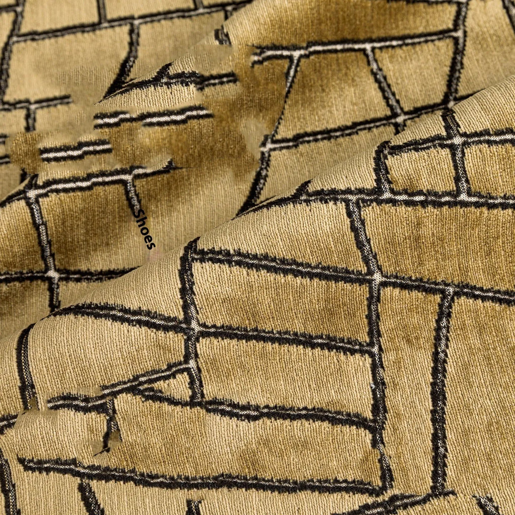 Geometric abstract patterned cushion cover in gold colour on a grey sofa, showing three size options.