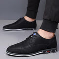 Men's black leather slip-on shoes with a rubber sole and leather toe cap on a grey background.