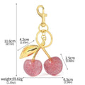 Red zinc alloy 3D cherry keychain pendant with metal loop for keyring attachment.
