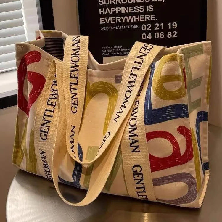 Large women's canvas tote bag with printed design, shown in available colour options.