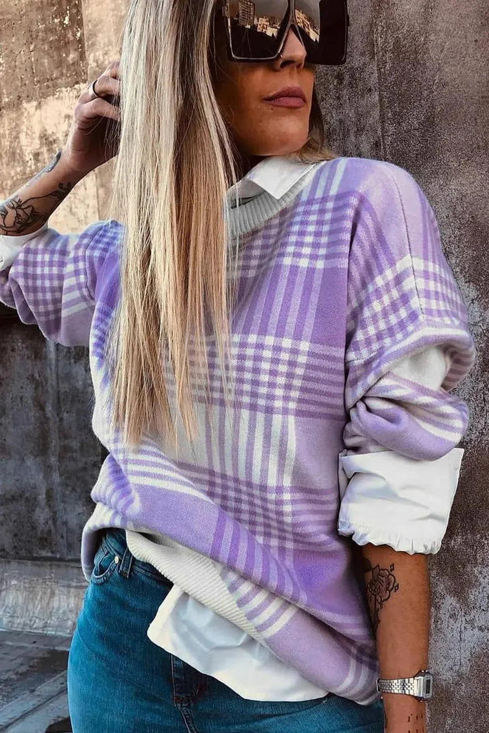Lilac plaid print loose women's sweater with ribbed collar and cuffs on a hanger.