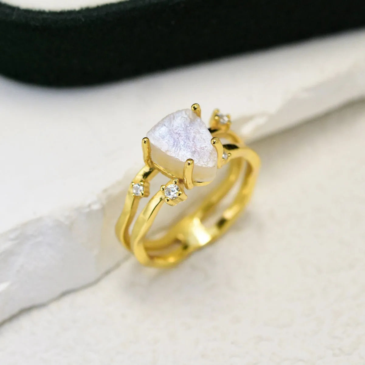 S925 silver geometric ring with irregular triangle shape and moonstone on a model's hand.