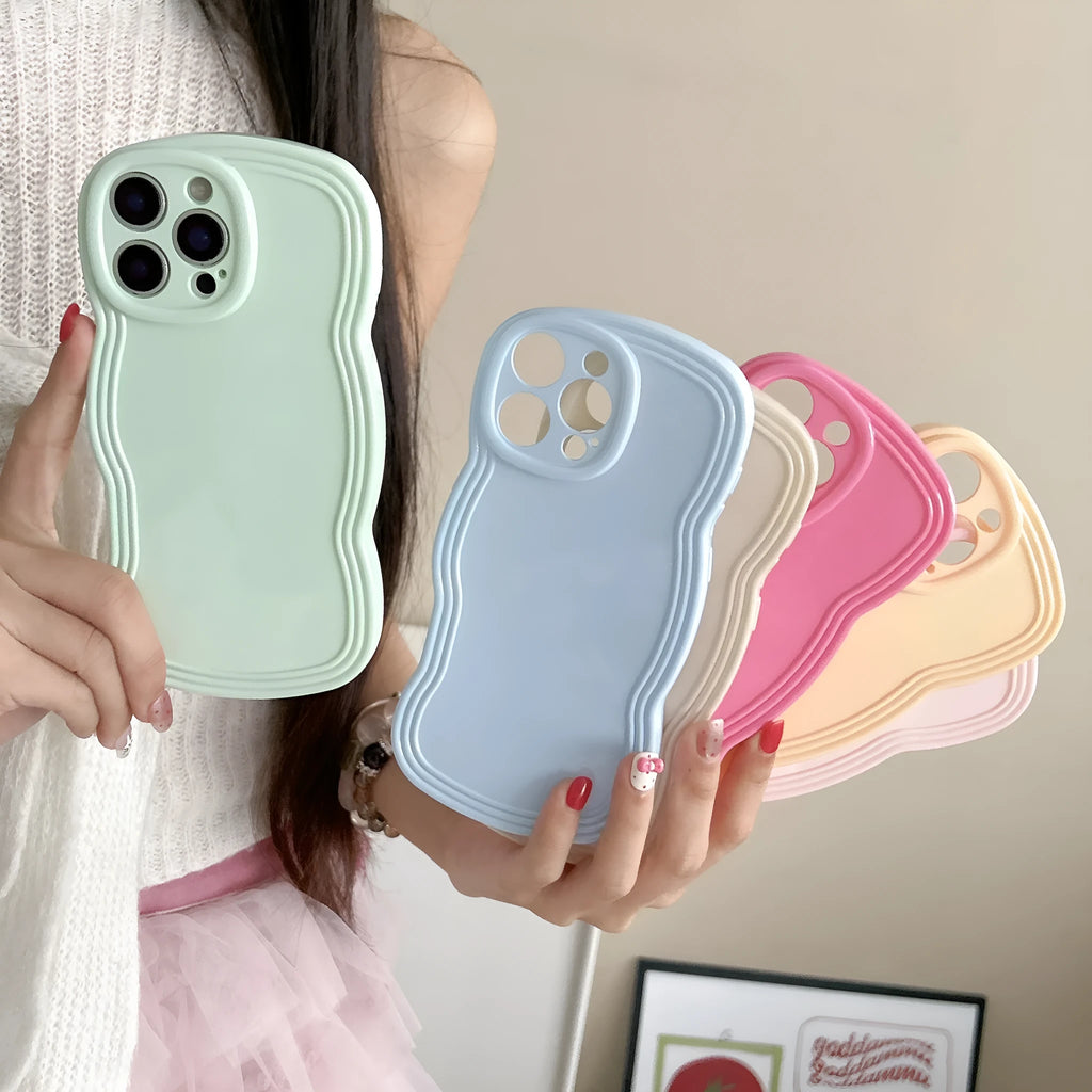 Glossy iPhone case with a soft cream and candy-colour wave pattern on a pink background.