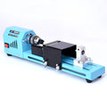 Mini DIY woodworking lathe in blue with protective cover, chuck, and accessories on a white background