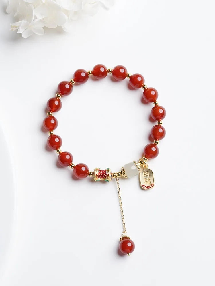 Gold-plated women's bracelet with red agate and Hetian jade beads in a traditional pattern.