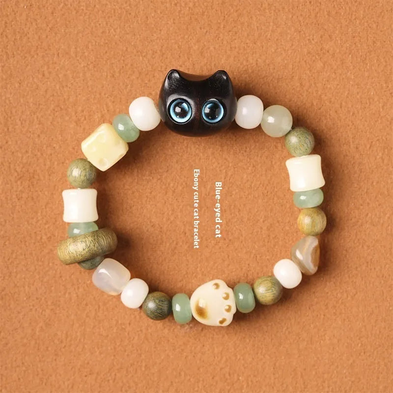 Hand-woven beaded bracelet with bodhi, jade, and ebony beads featuring a cartoon cat's paw charm.