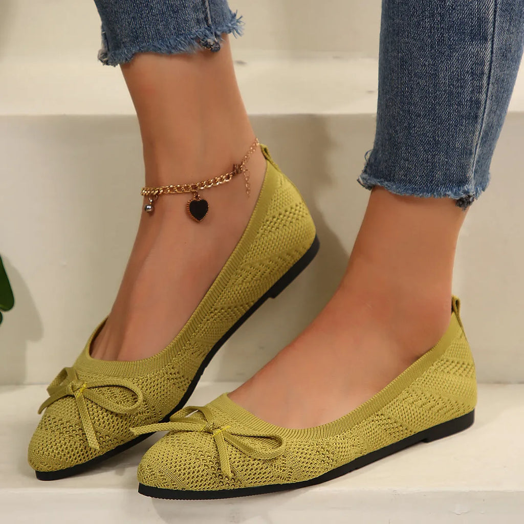 Women's blue knitted flat loafer with bow detail on pointed toe, showing rubber sole