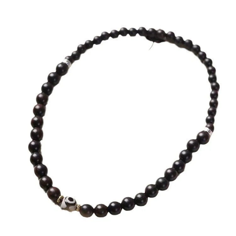 Dark ebony wood bracelet with 8mm Tibetan style beads showing two-circle pattern design