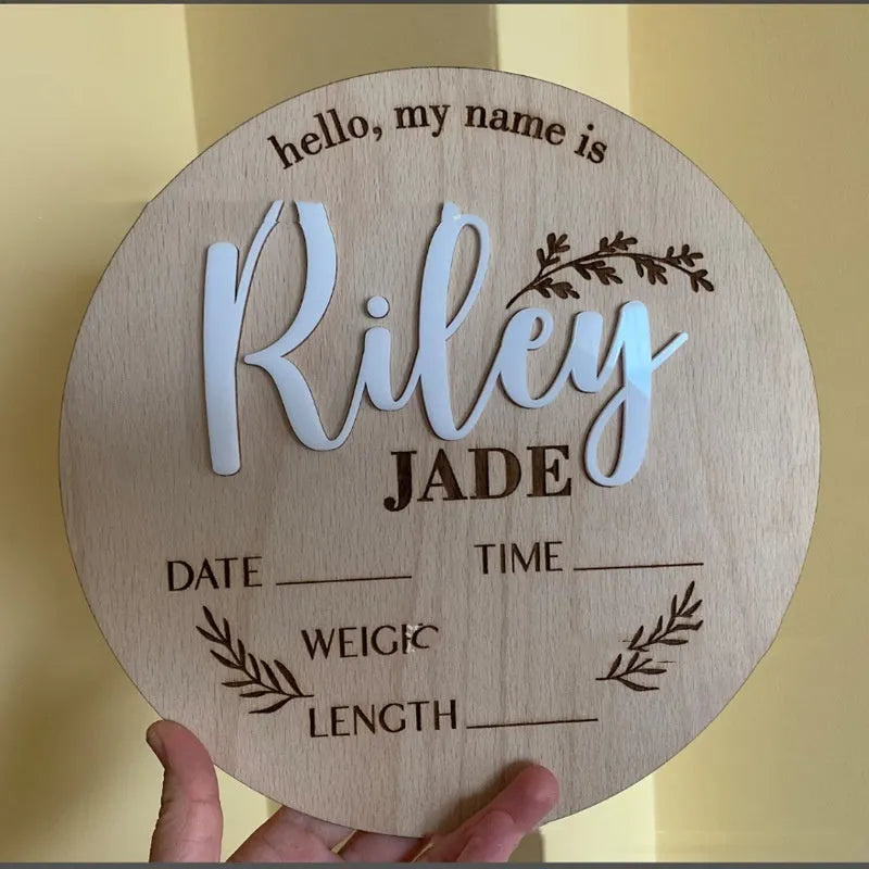 Square wooden newborn name plaque showing baby birth information and surname.