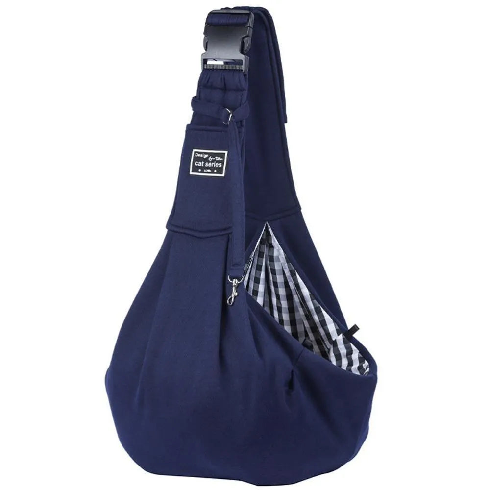 Light grey polyester pet sling carrier with cell phone pocket, worn around waist, holding a small dog
