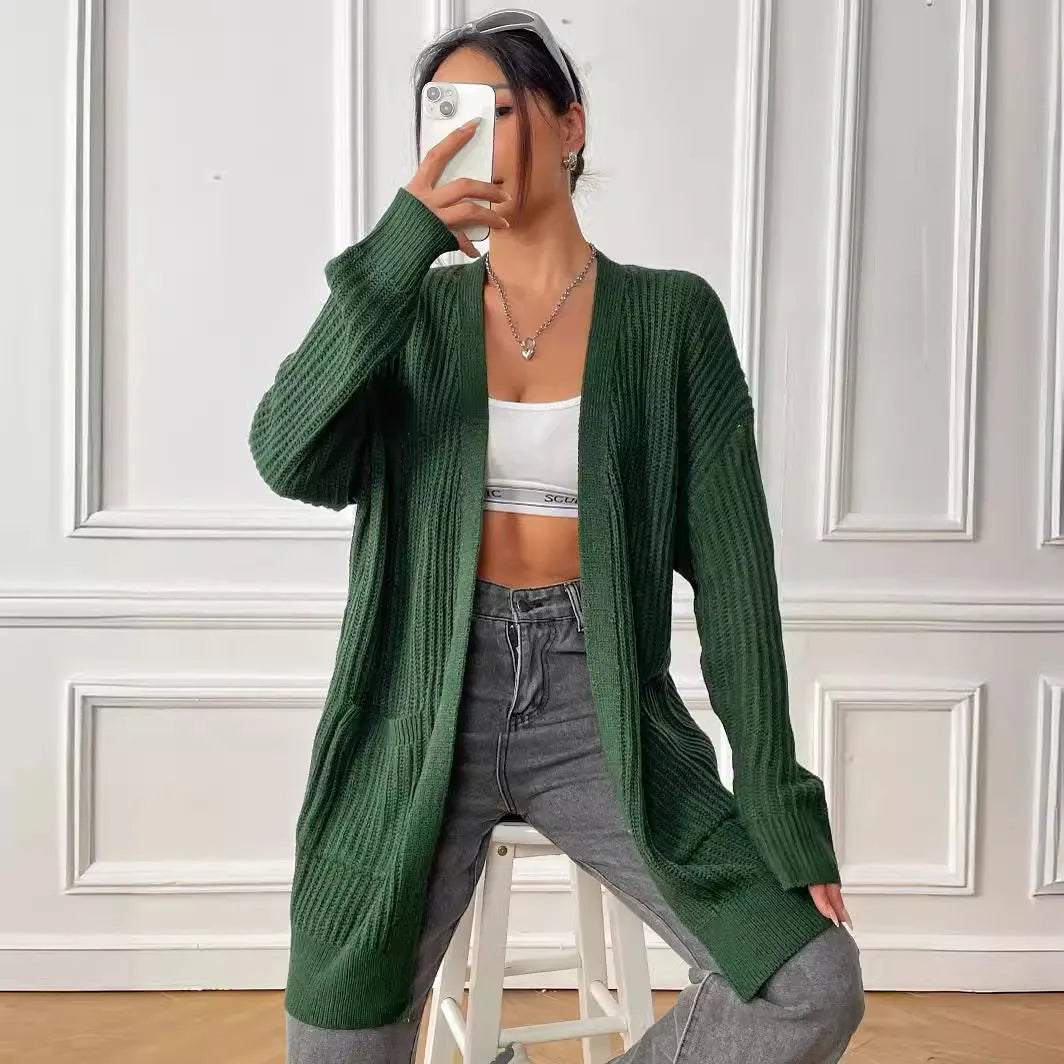 Women's dark green double pocket casual cardigan sweater laid flat.