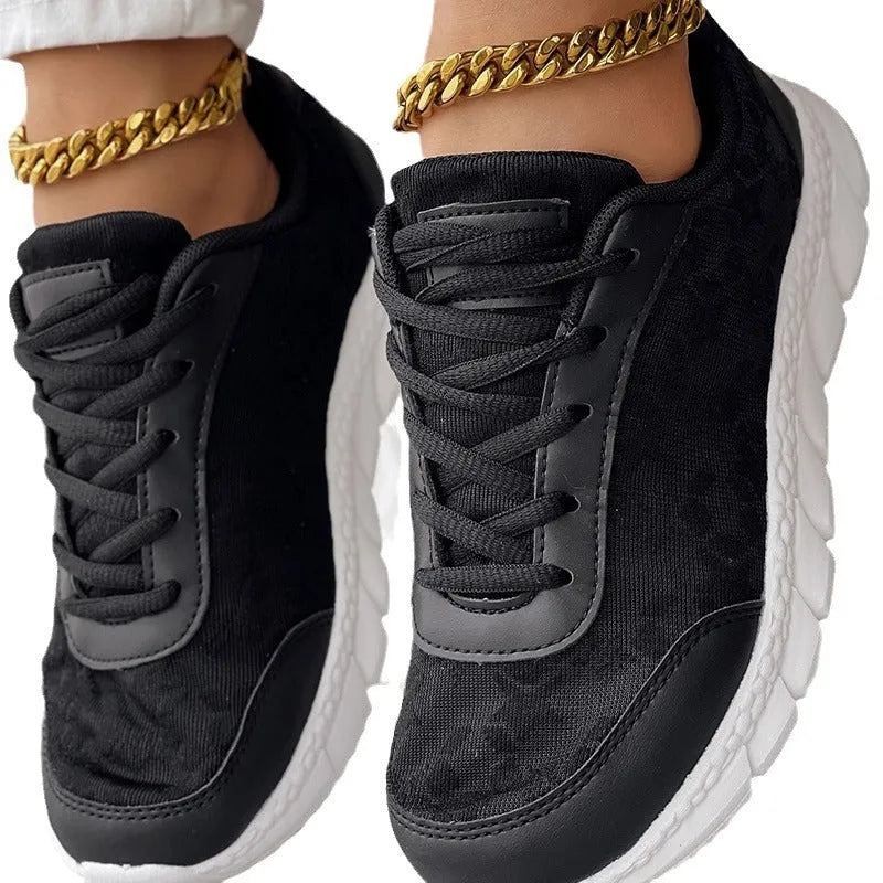 Women's white canvas running shoes with a round toe, flat heel, and soft sole on a neutral background.