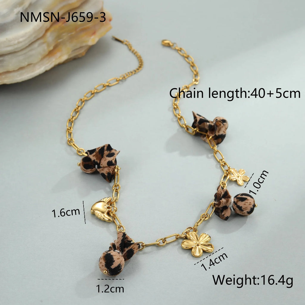 Stainless steel necklace with a geometric leopard pendant and heart and flower accents on an adjustable chain.