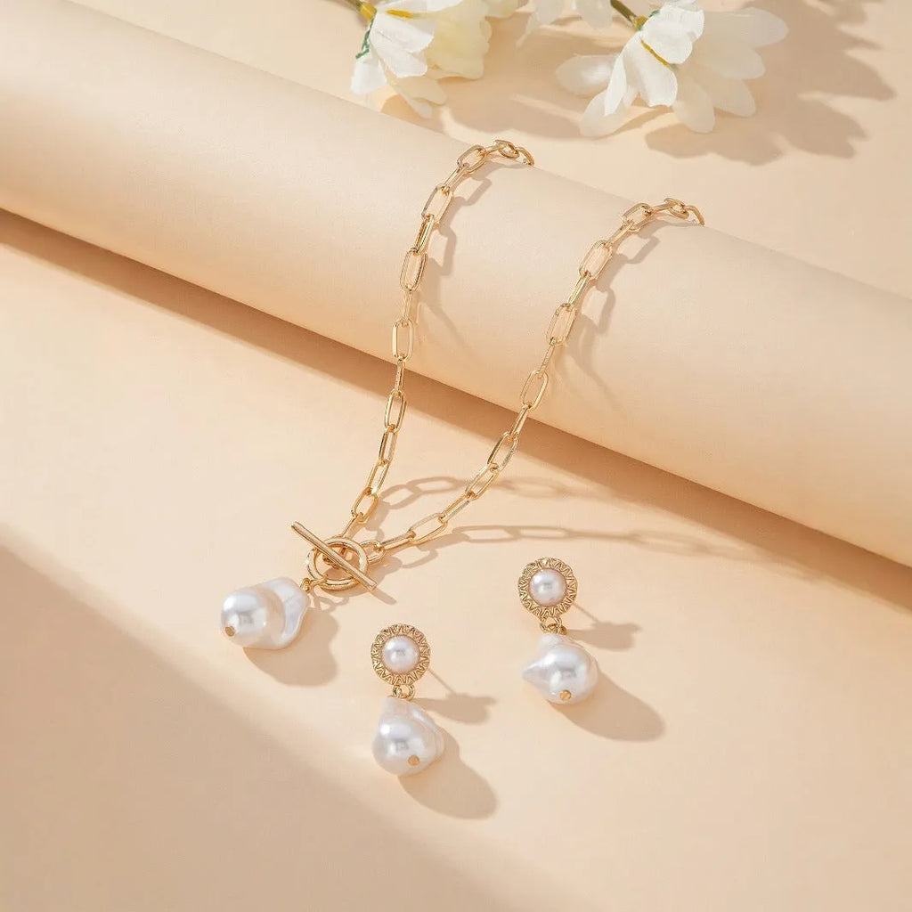 Gold-tone retro baroque necklace and earring set with a pearl pendant on an iron chain.