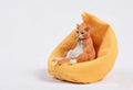 Lazy cat car ornament resin model with fabric sofa on a dashboard.