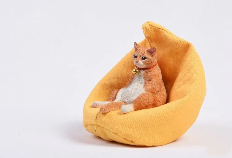 Lazy cat car ornament resin model with fabric sofa on a dashboard.