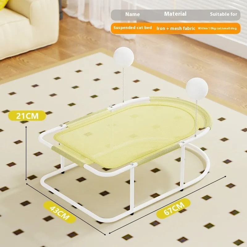 Grey fabric cat kennel with open sides and a round, removable floor pad on a carpet.