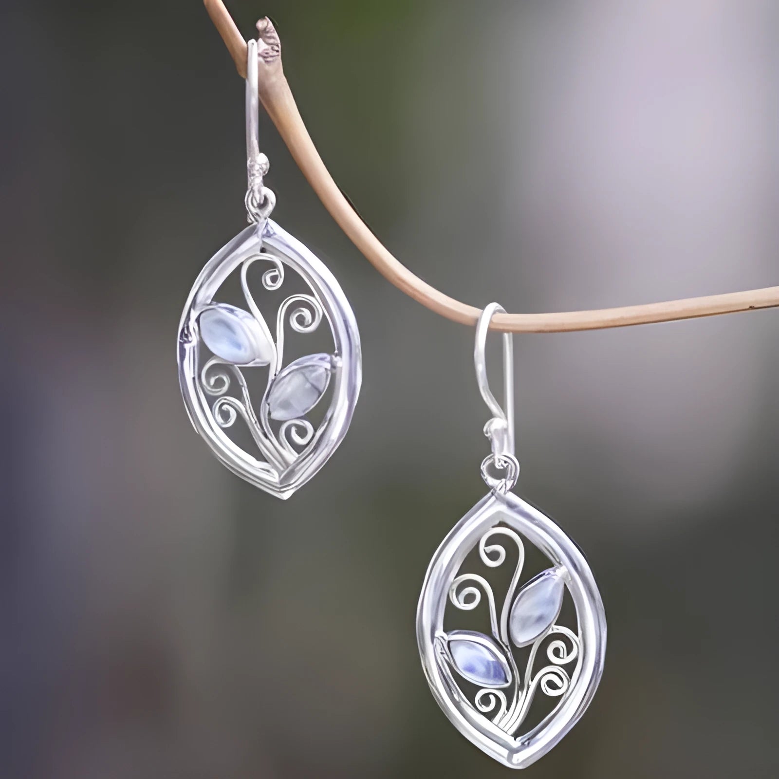 Silver colour alloy earrings with a leaf design and embedded colourful moonstones for women.