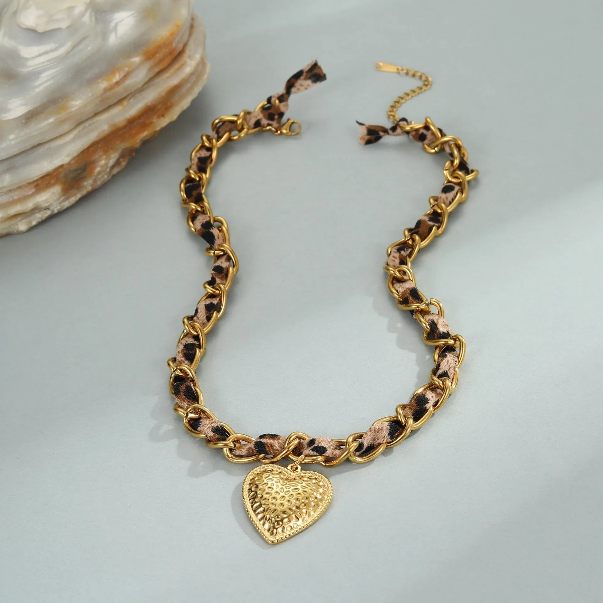Geometric leopard love pendant necklace on a stainless steel chain with 18K gold electroplate.