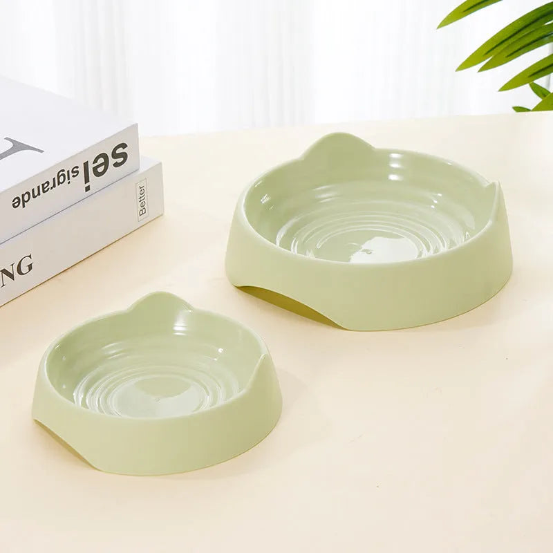 Blue ceramic dog slow feeder bowl with internal maze design, shown next to a green and pink version.