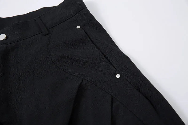 Men's black pleated wide-leg cotton trousers showing loose-fitting casual design