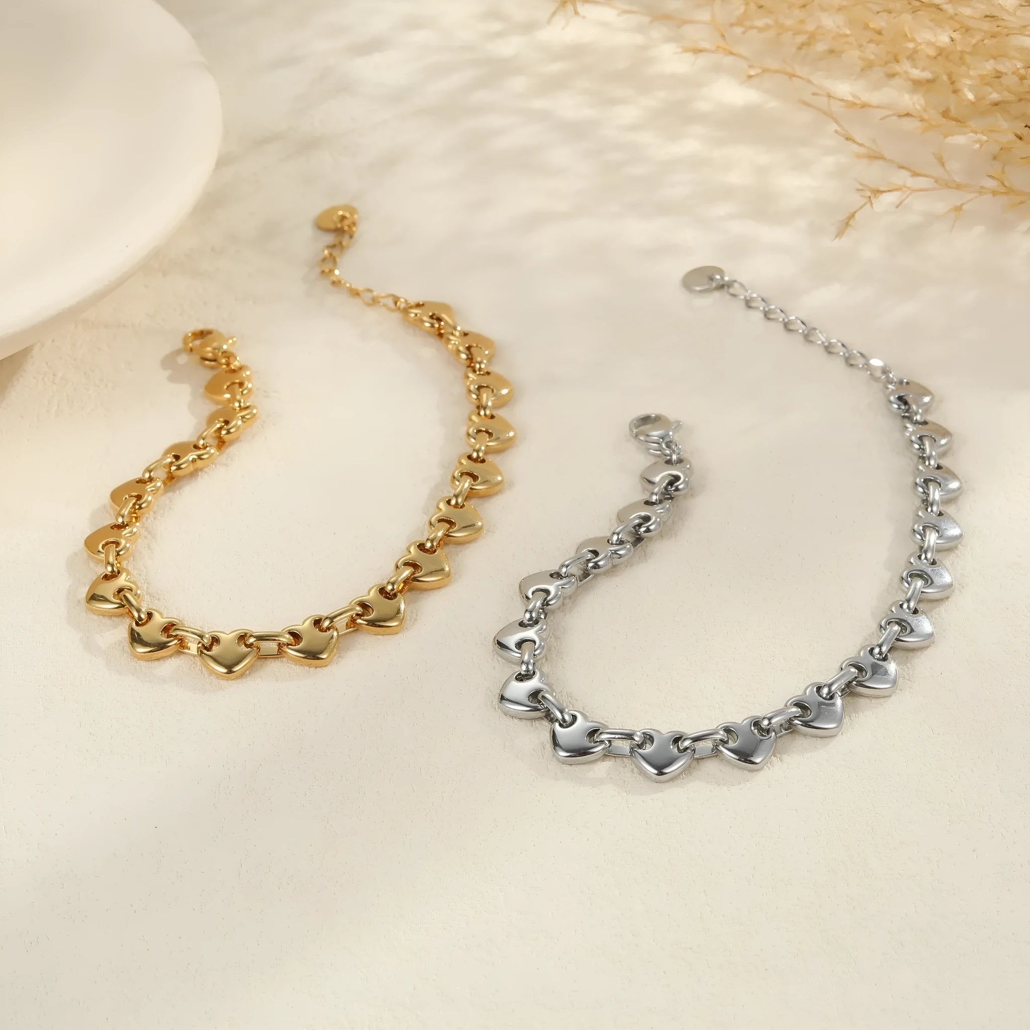 Women's stainless steel bracelet with a hollow geometric heart charm in gold or steel colour.