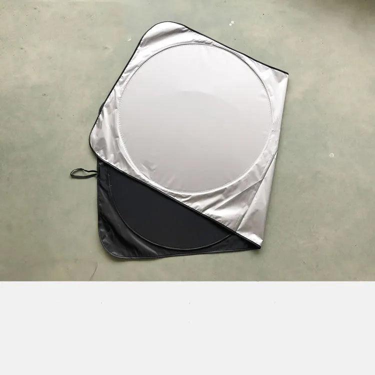 Large silver reflective car sunshade folded next to its cloth storage bag