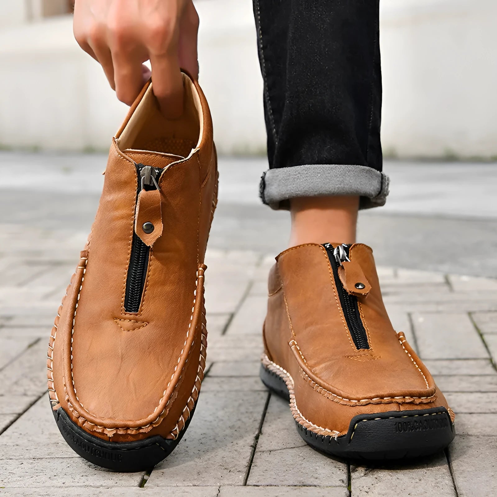 Men's black slip-on loafers with round toe and stitched sole on a plain background