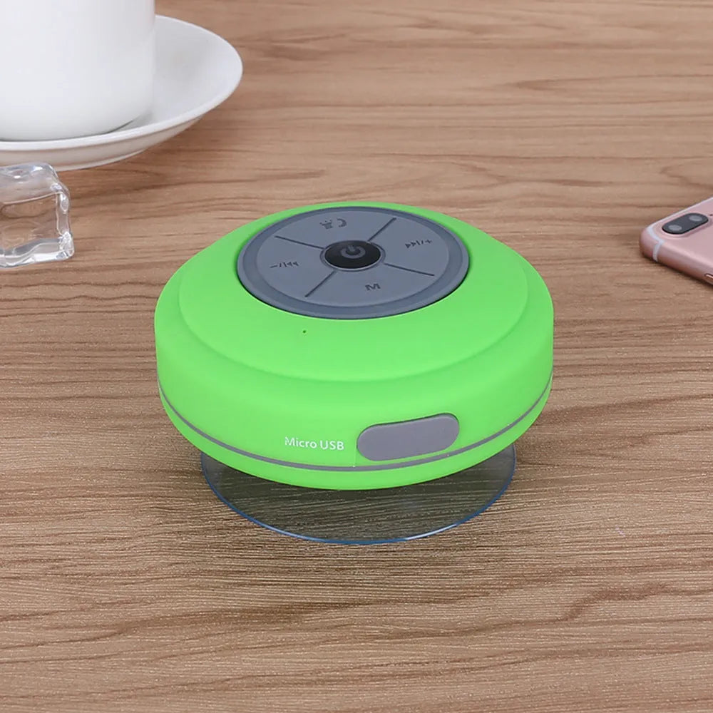 Waterproof suction cup Bluetooth speaker in black attached to a tiled wall