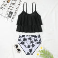 Black high waist swimsuit briefs and sleeveless top with coconut tree print, laid flat.