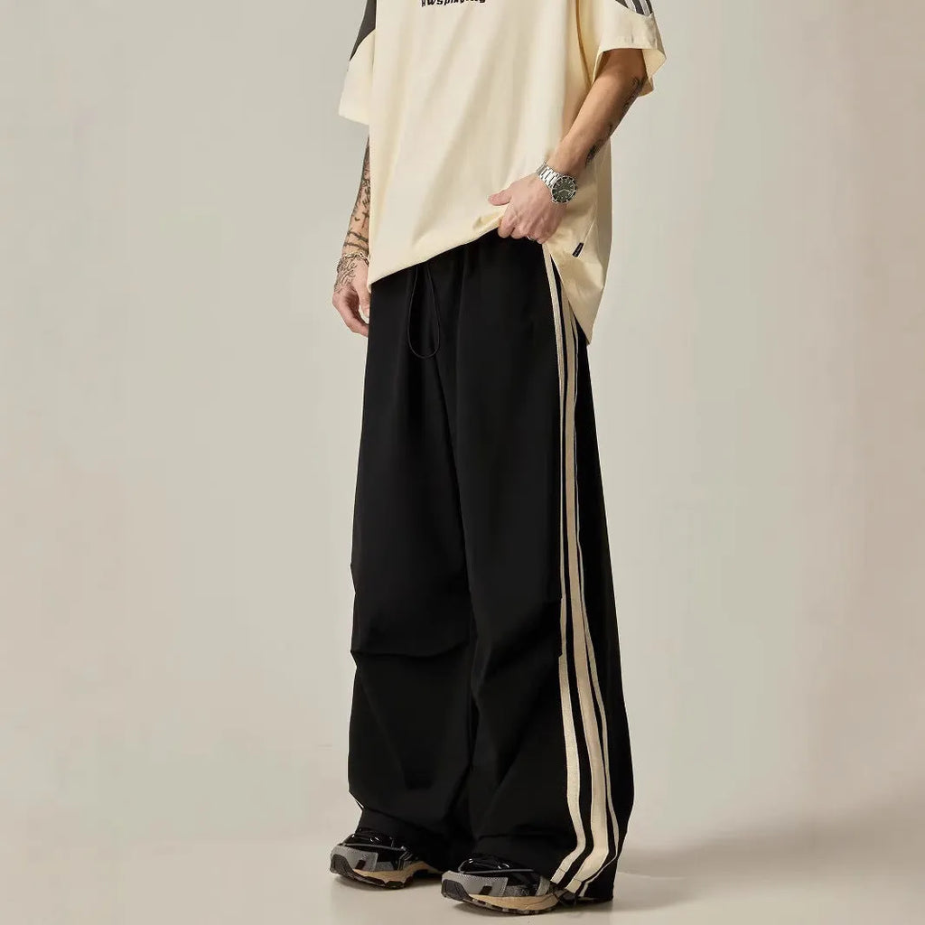 Black men's wide-leg high-waist climbing trousers laid flat, showing straight-leg cut.