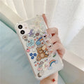Transparent TPU iPhone case with bear chain and pendant attachment showing phone protection