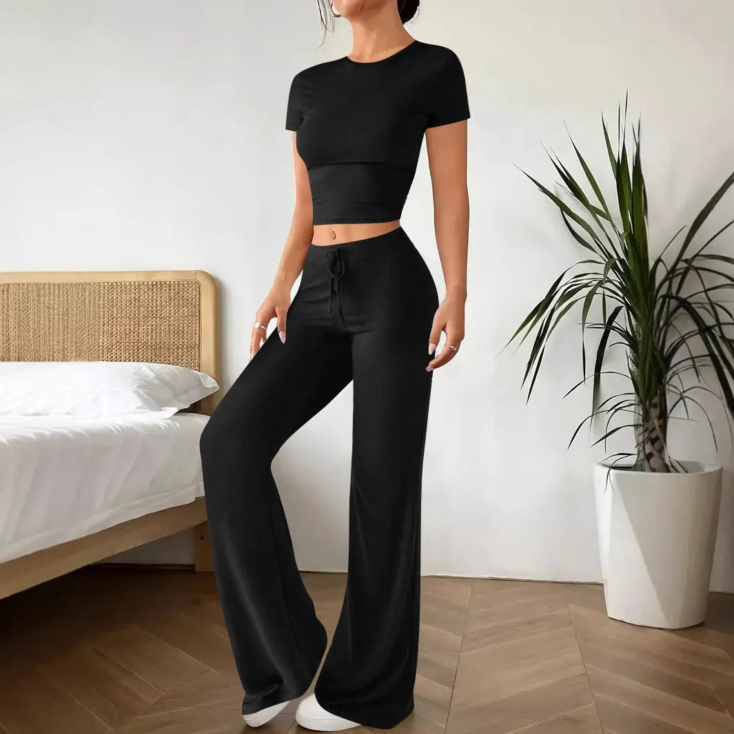 Black women's high waist trousers and short sleeve T-shirt lounge suit set on a plain background.